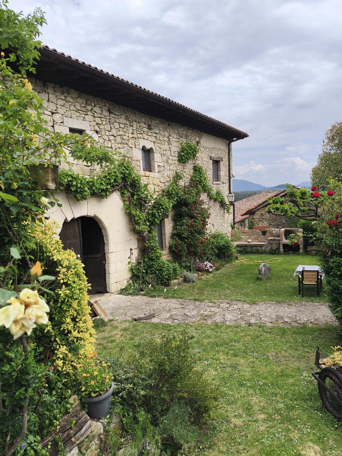 El jardín de TTipiaenea en primavera, con la casa de piedra al fondo